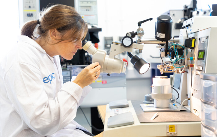 Photography of a scientist at work using specialist microscopy within the photonics industrty in Devon.
