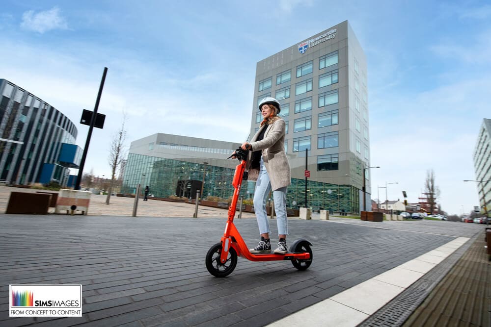Photography of model outside Newcastle University riding an electric scooter